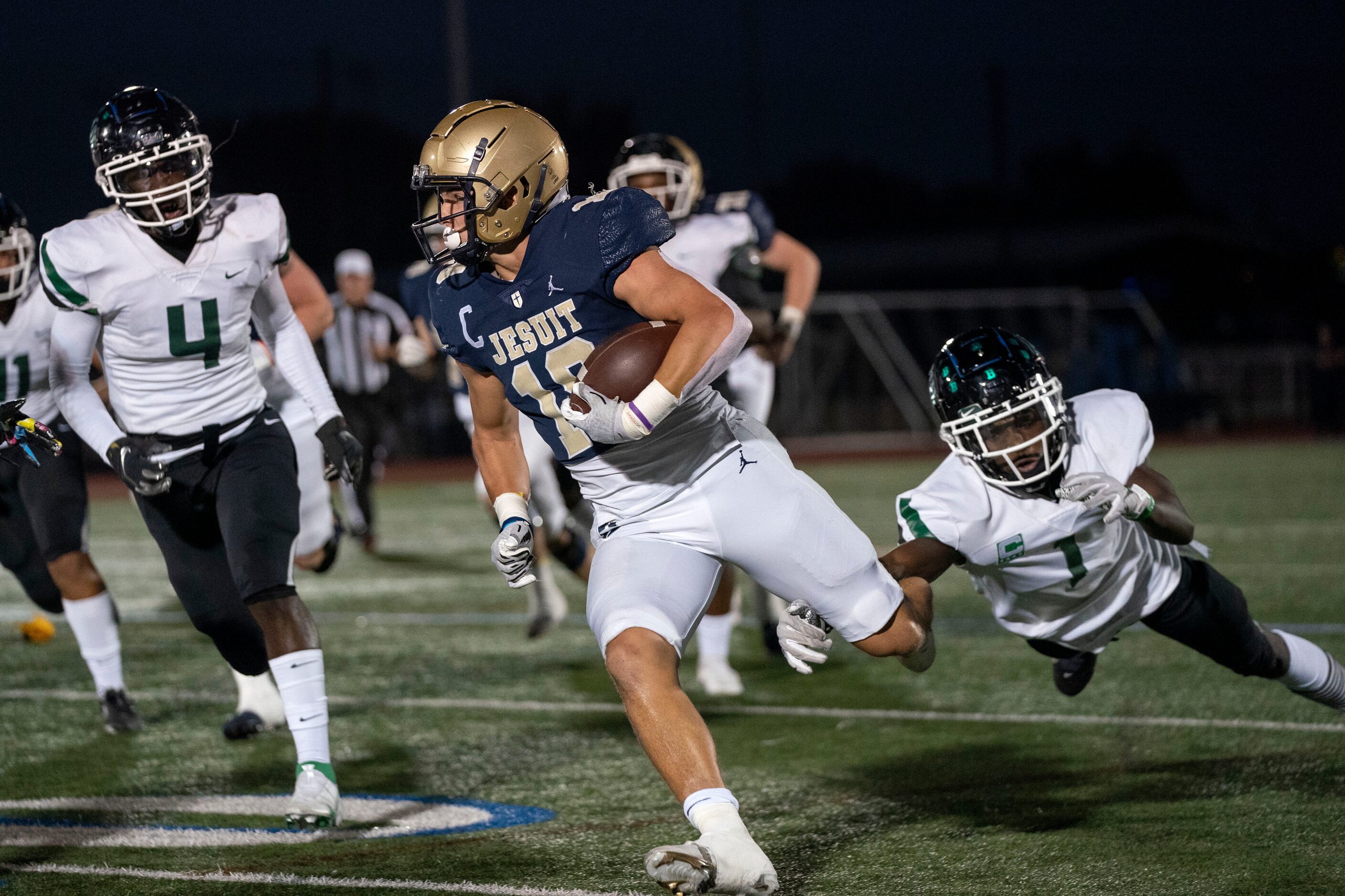 Jesuit senior running back Robert Fitzgerald (18) turns upfield past Richardson Berkner...