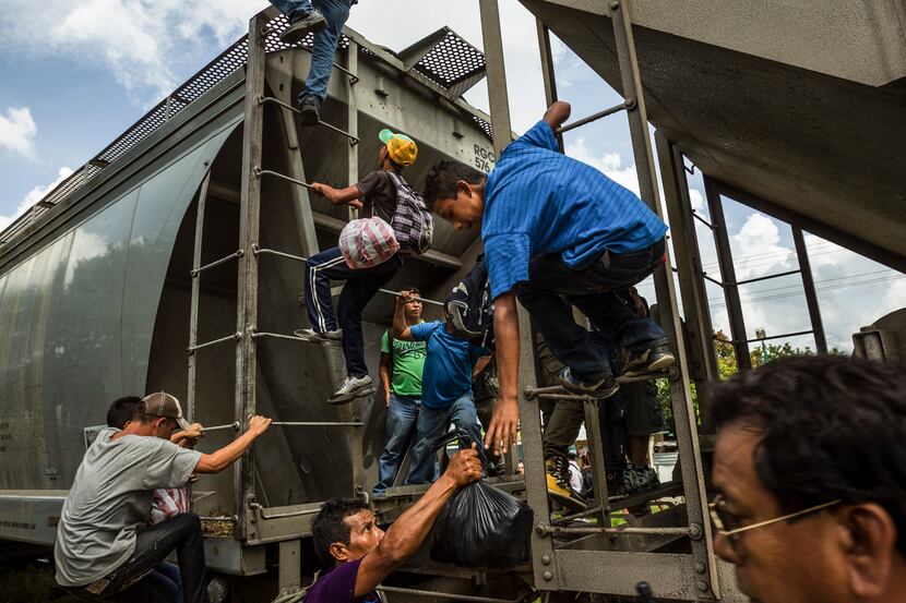 Migrants ran and climbed aboard a northbound freight train known as “The Beast” as it passed...