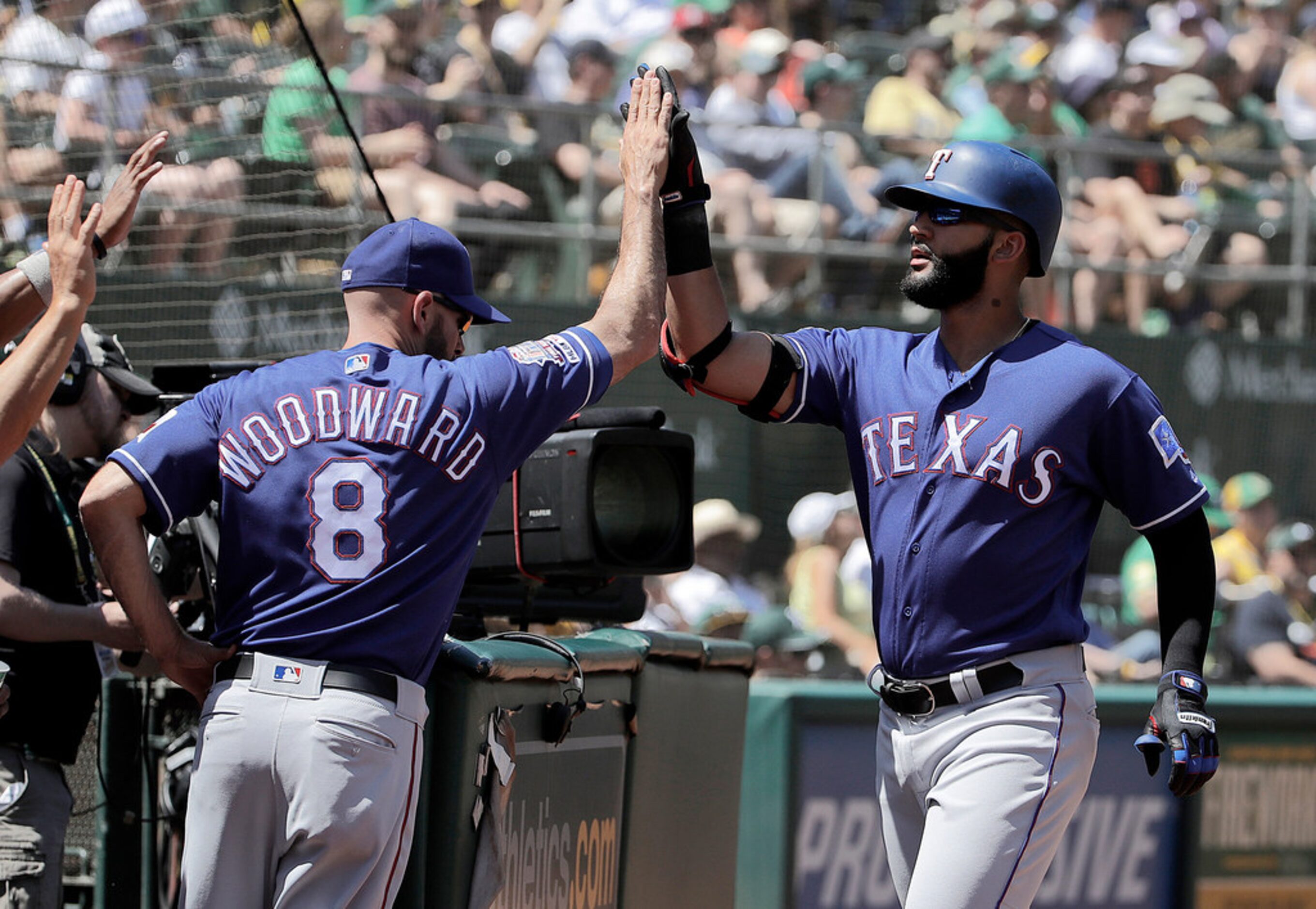 Texas Rangers' Nomar Mazara, right, is congratulated by manager Chris Woodward (8) after...