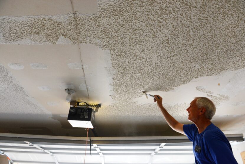 Plain-O Helpers founder Fred Clark scrapes the ceiling of a Plano resident's garage. The...