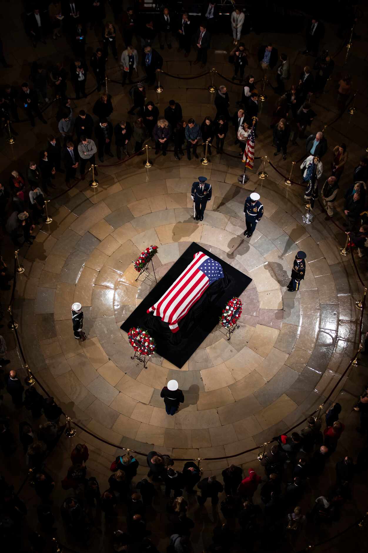 Visitors pass the flag-draped casket of President George H.W. Bush in the rotunda of the...