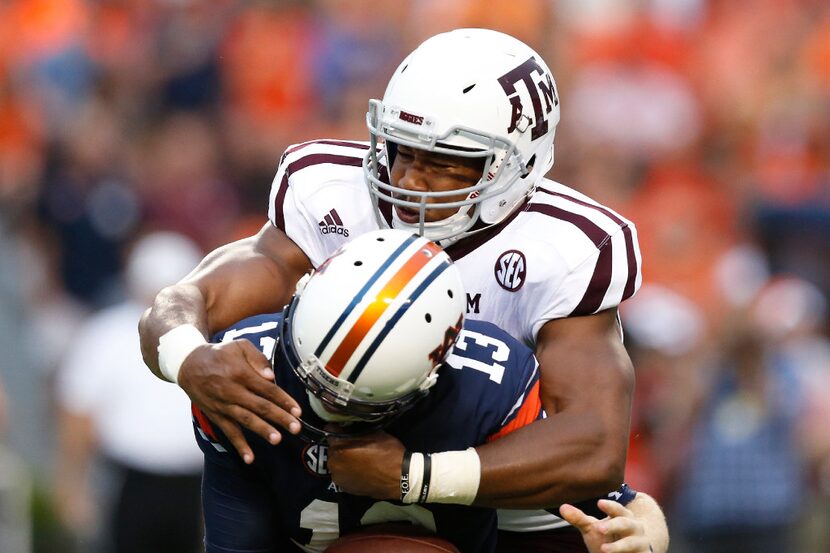 FILE - In  this Sept. 17, 2016, file photo, Texas A&M defensive lineman Myles Garrett, top,...