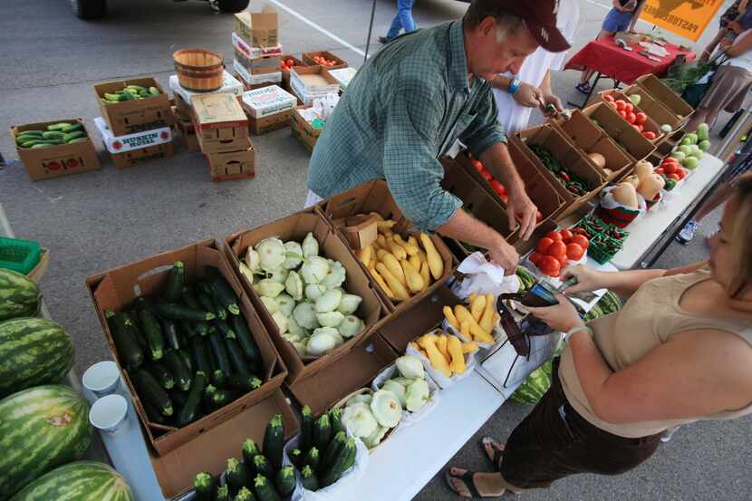 Jenny Witten of Bedford purchases produce from David Fisher of Fisher Farms, at Coppell's...