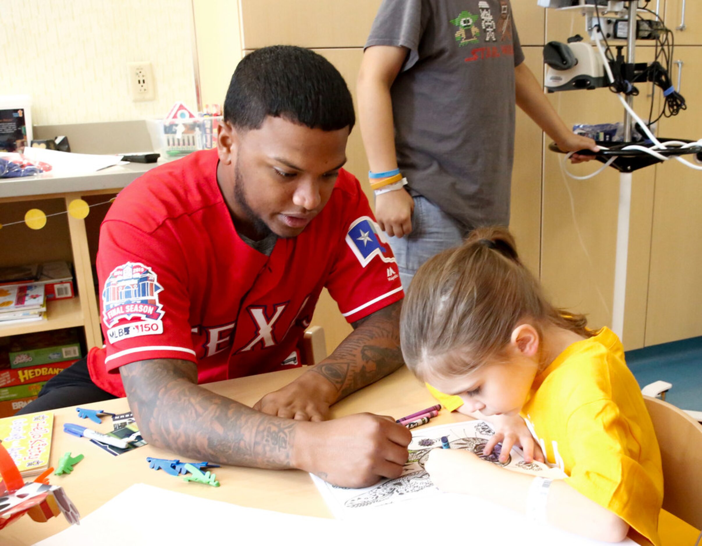 Texas Rangers outfielder Willie Calhoun colors with 7-year-old patient Danielle Gonzalez at...