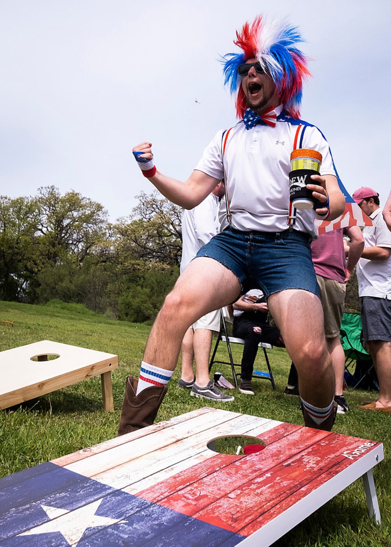 Fans Clayton Ferrell celebrates as he plays cornhole while tailgating before the Texas...