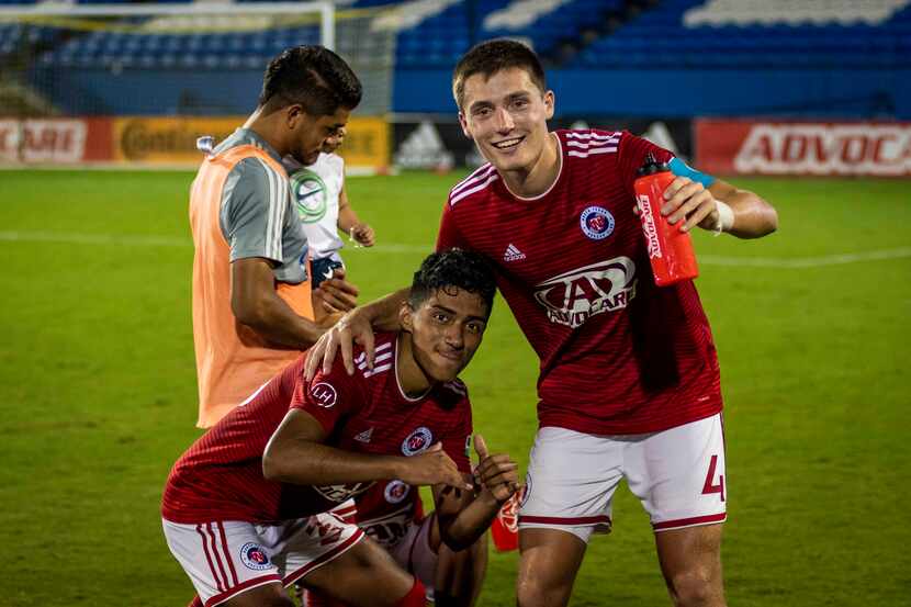 Brecc Evans (4) and Gibran Rayo (39) celebrate a 4-0 win in North Texas SC's final regular...