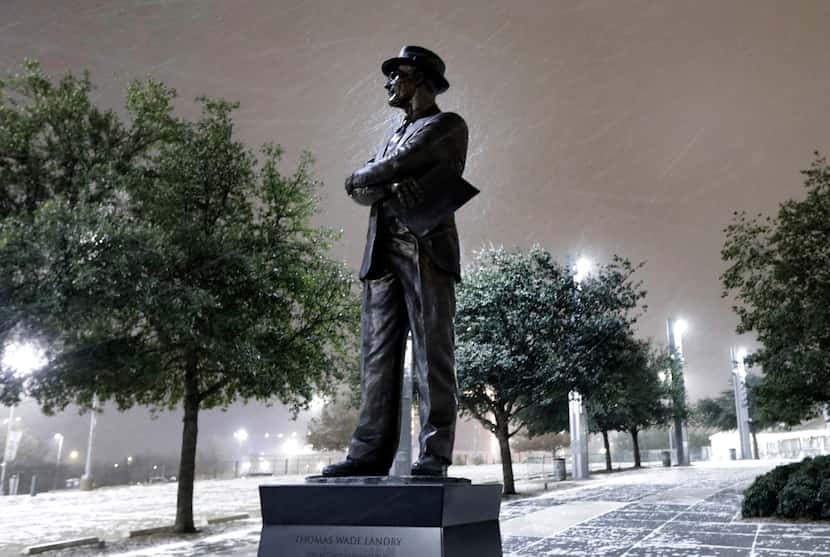 Light snow falls outside AT&T Stadium and the Tom Landry statue following the Dallas Cowboys...