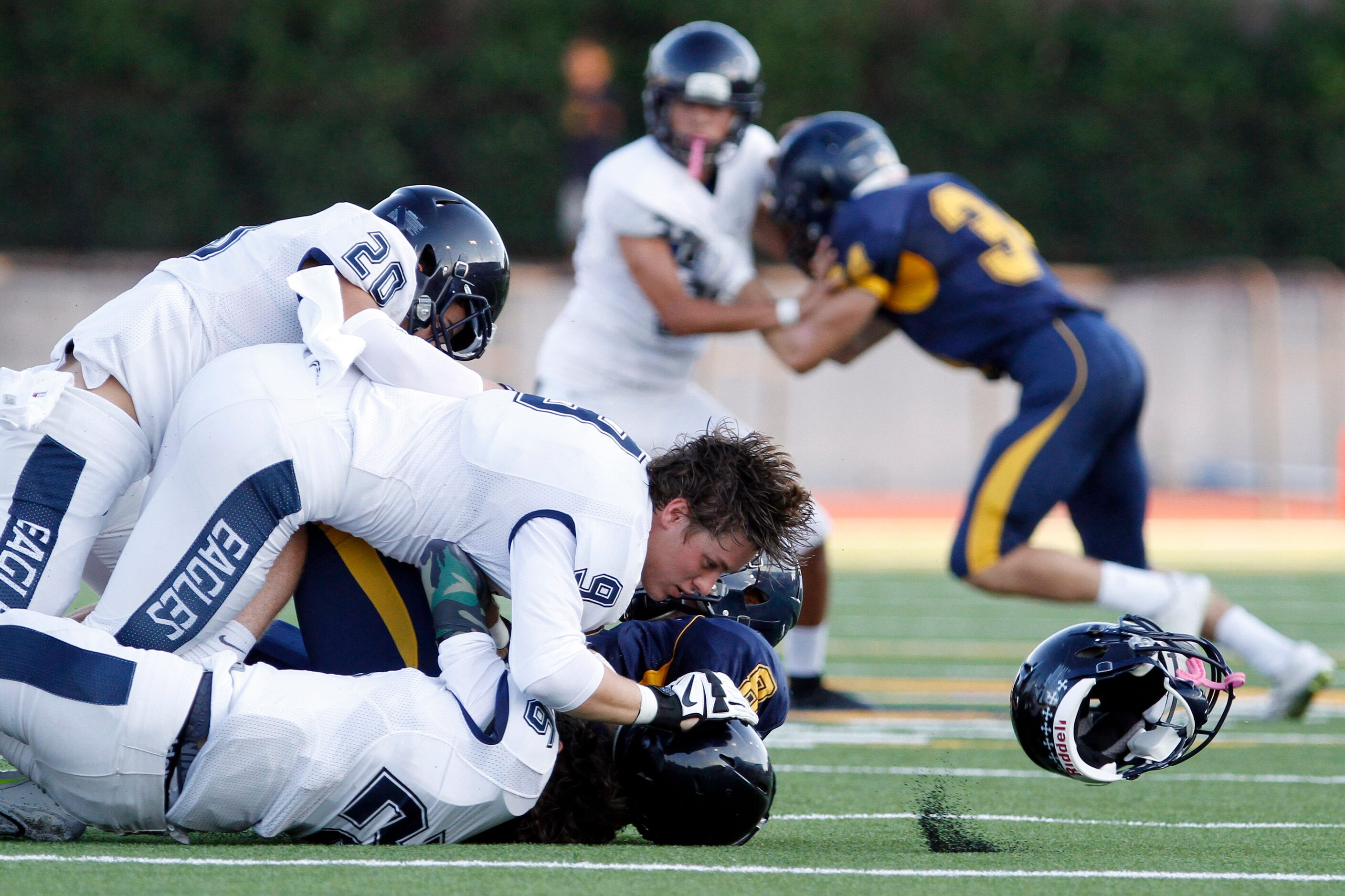 Episcopal School of Dallas defensive end Ryan Brennan (09) loses his helmet after a hit on...