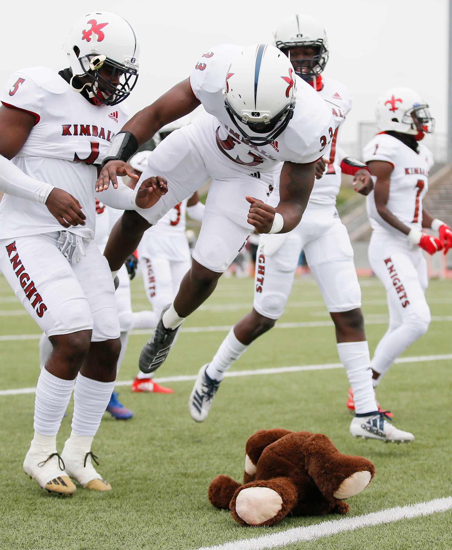 Kimball junior defensive end Donald Miles (33) leaps onto a stuffed bear, South Oak Cliff’s...