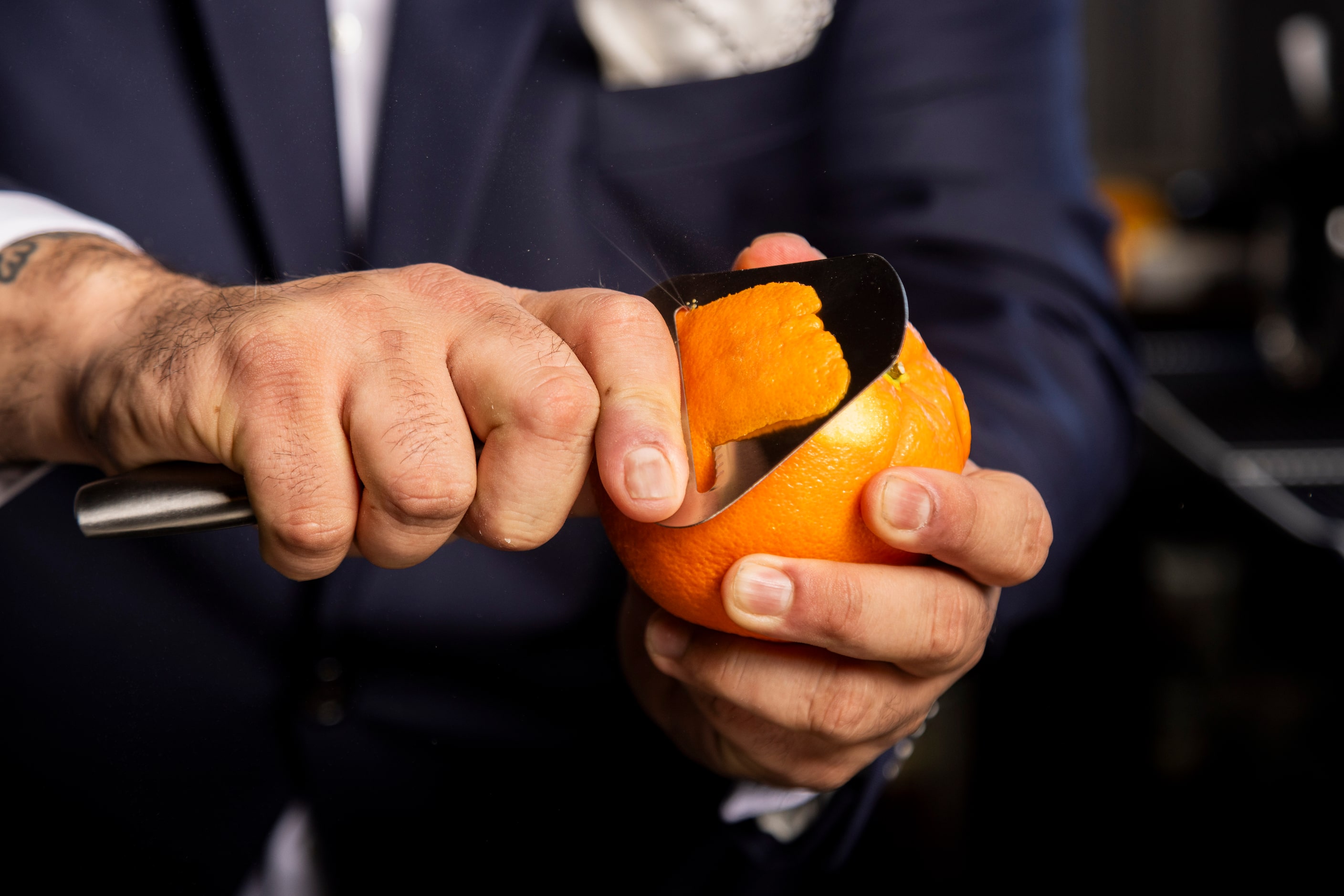 Juice shoots out of an orange as beverage director Ravinder Singh cuts an orange peel for...