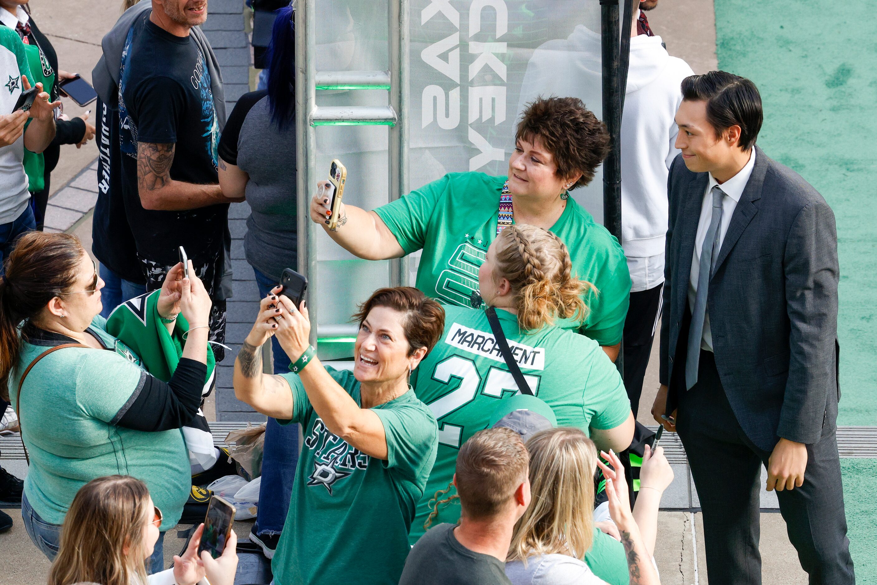 Dallas Stars left wing Jason Robertson poses for a photo with fans on the green carpet to...