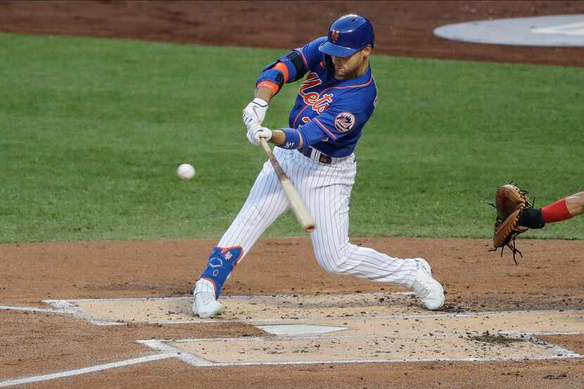 New York Mets' Michael Conforto hits a single during the first inning of a baseball game...