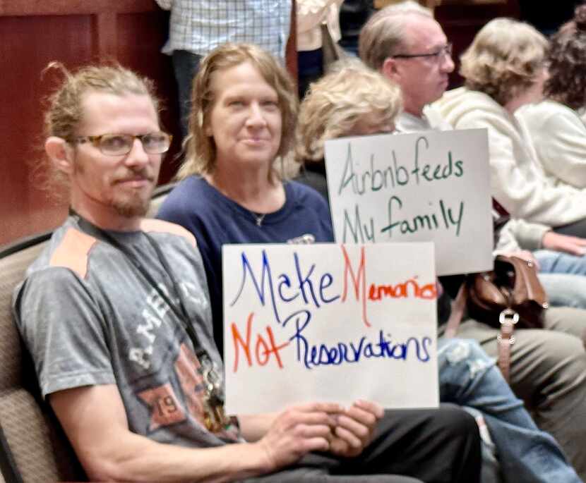 Cory Montemayor (left) and Gwendolyn Wager hold signs during a public hearing in Lewisville...