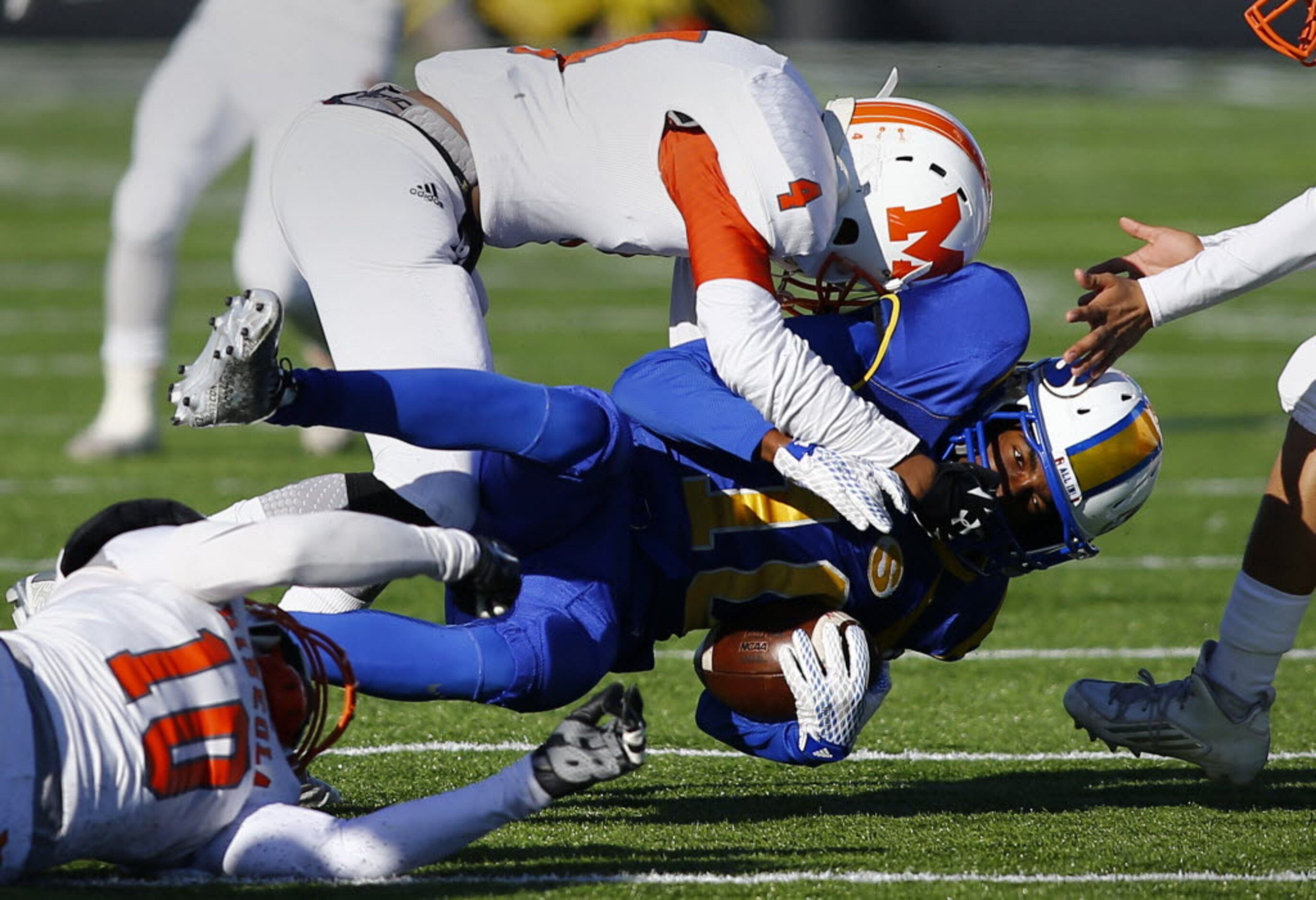 TXHSFB Sunnyvale's Julius Kirven (10) is tackled by Mineola's Trajan Johnson (4) and Kartney...