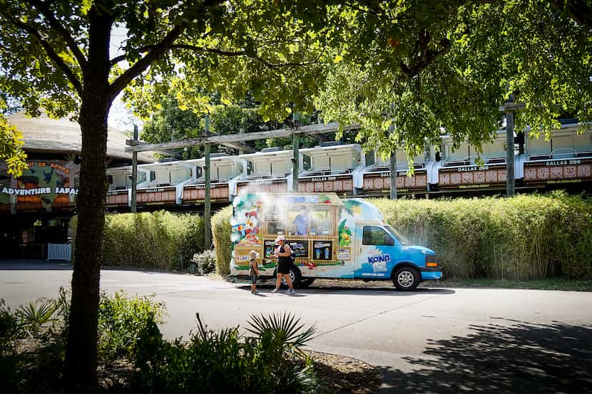 Guests stop for shaved ice beneath the Adventure Safari Monorail at the Dallas Zoo on Thursday.