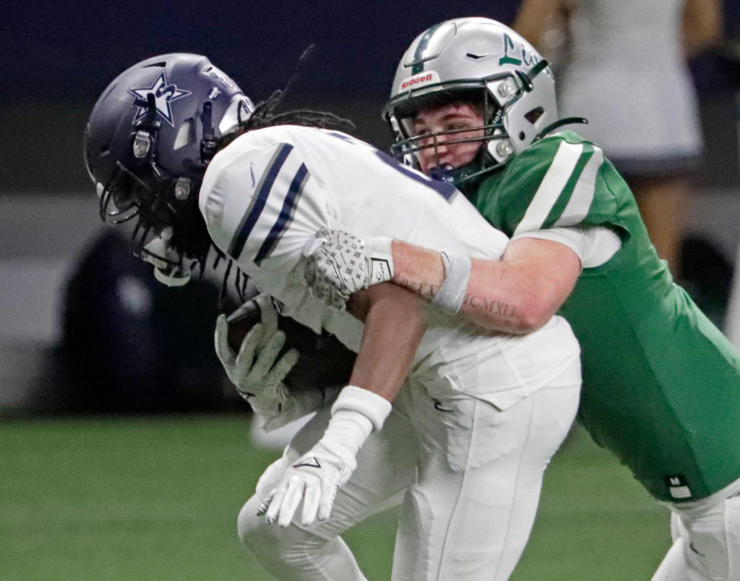 Reedy High School defensive back Cooper Clabo (5) hangs on to tackle Lone Star High School...