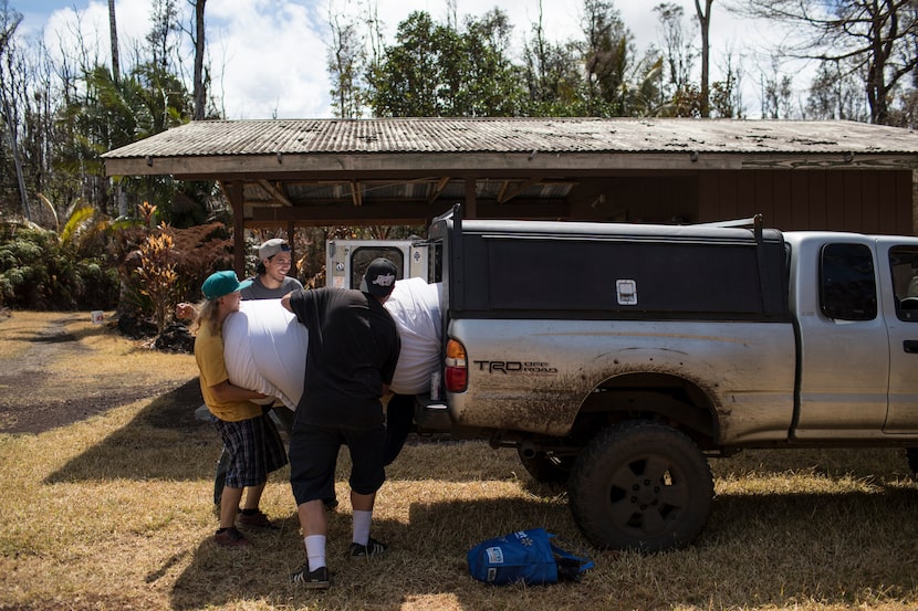 From left: Brandon Lofgreen, Thomas Robinson and Jeremiah Lofgreen retrieve a mattress for a...