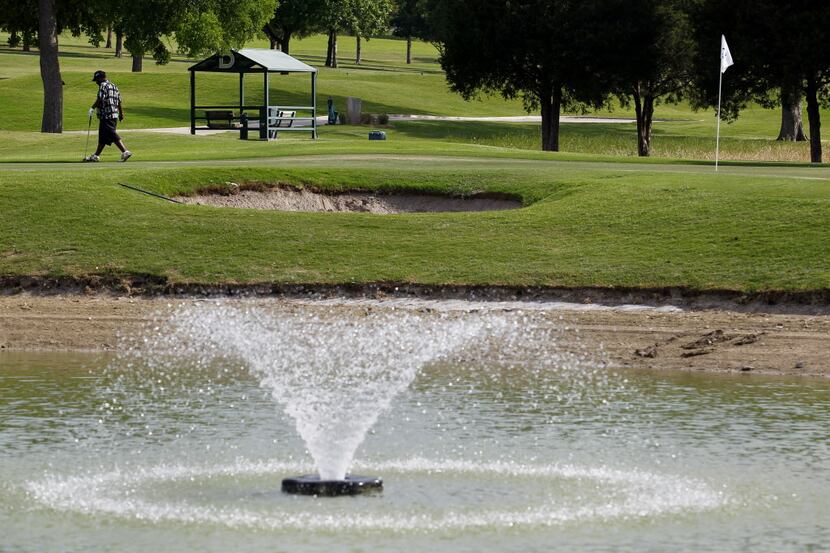 Golfer Anthony Smith, of Atlanta, walks by the pond at Cedar Crest Golf Course retaining...