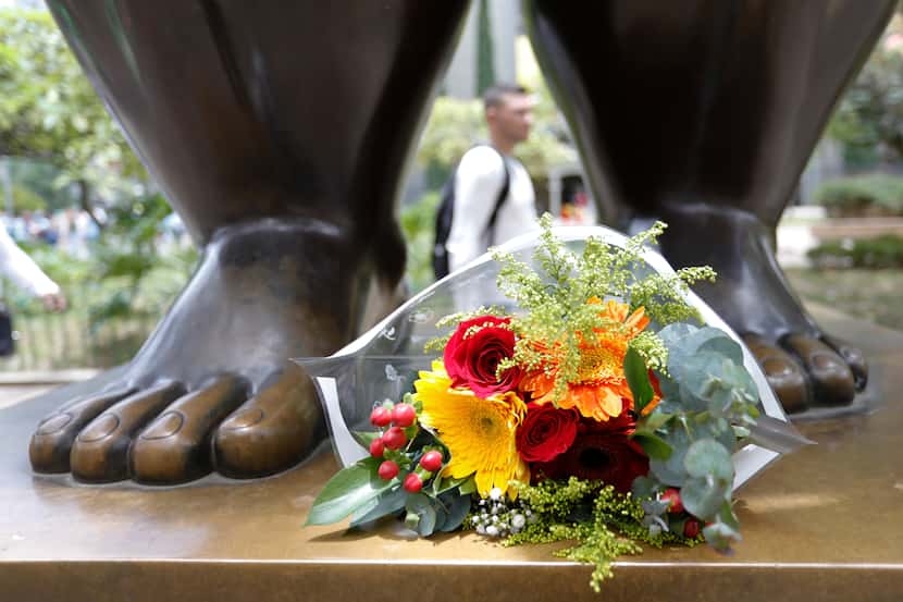 Flowers sit at the feet of a sculpture by Colombian artist Fernando Botero at Botero Park in...