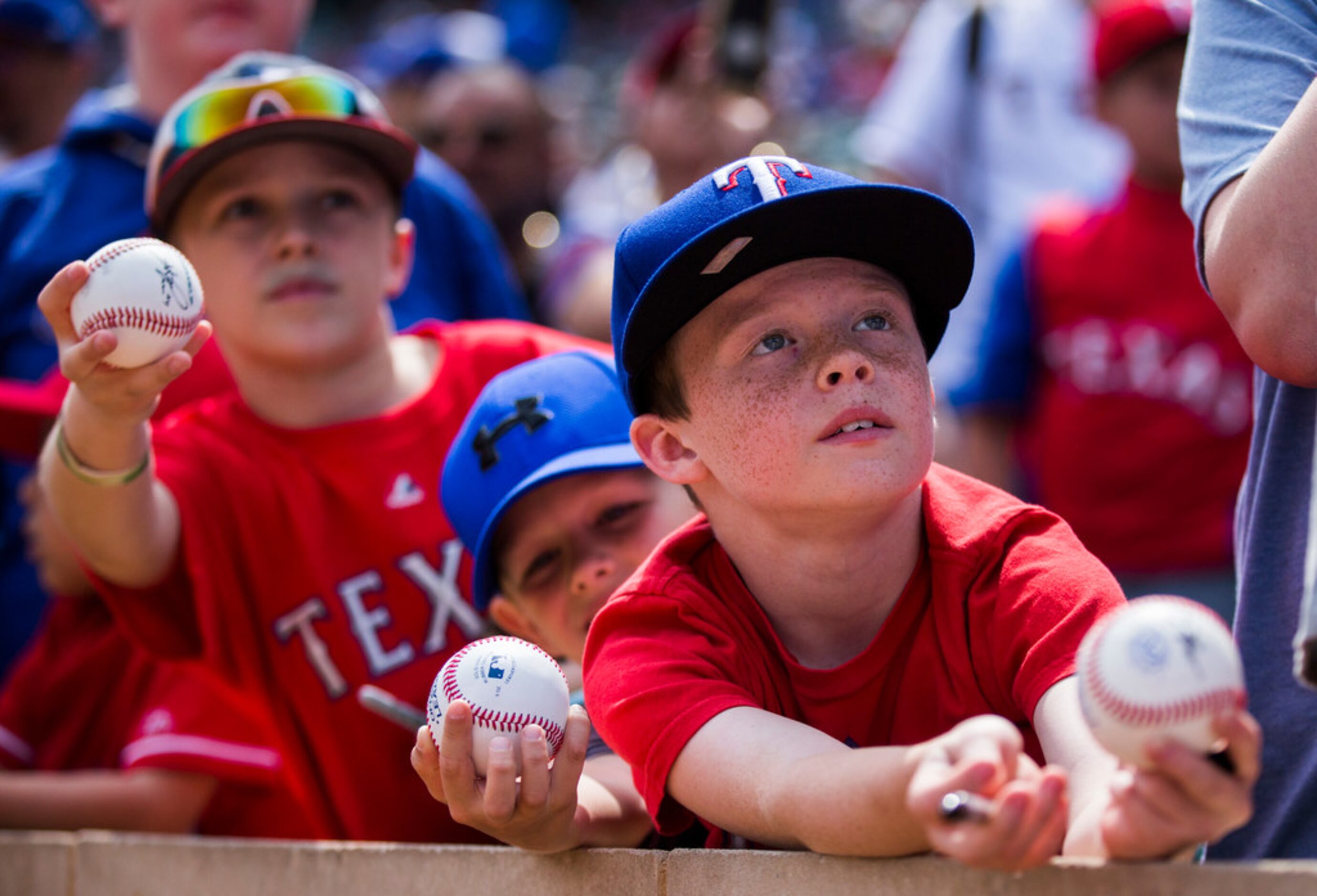 Young fans wait for autographs before an opening day MLB game between the Texas Rangers and...