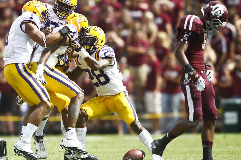 LSU players swarm and celebrate corner back Tharold Simon (24) after an interception against...
