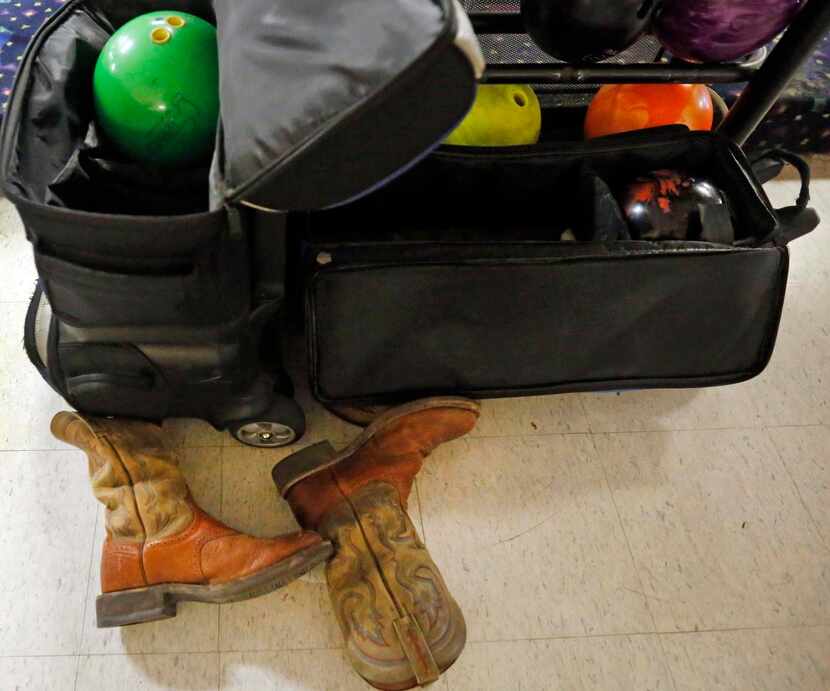 
Allen boys bowling team’s custom bowling balls are shown next to a pair of cowboy boots....