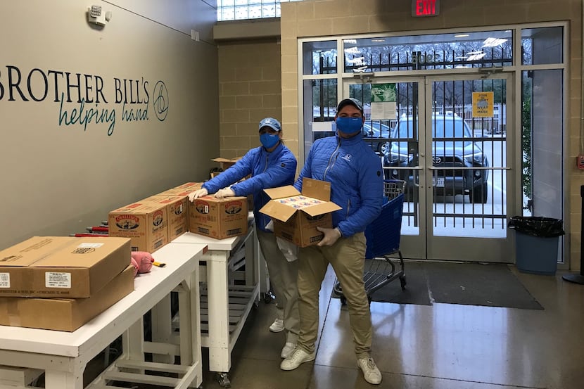 Two masked volunteers and Helpful Honda Guys move boxes at Brother Bill's Helping Hand.