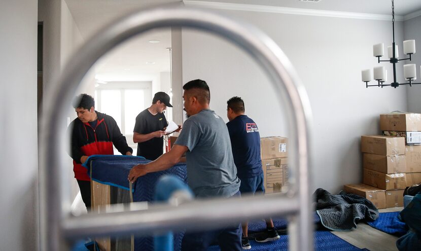 Movers unload belongings inside the Rosvolds' newly purchased house.