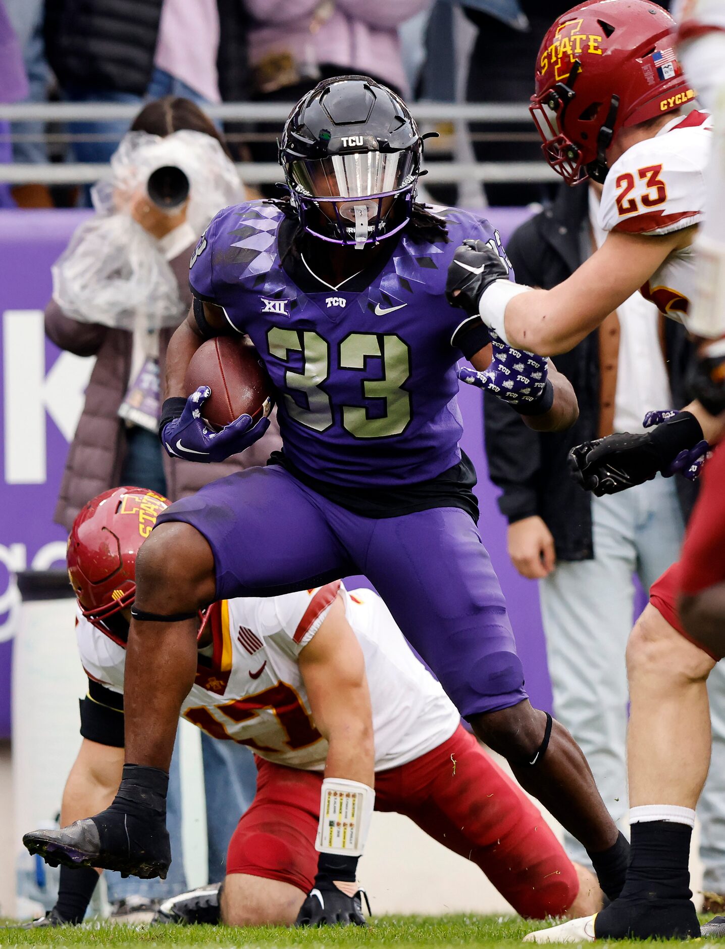 TCU Horned Frogs running back Kendre Miller (33) fights his way past several Iowa State...