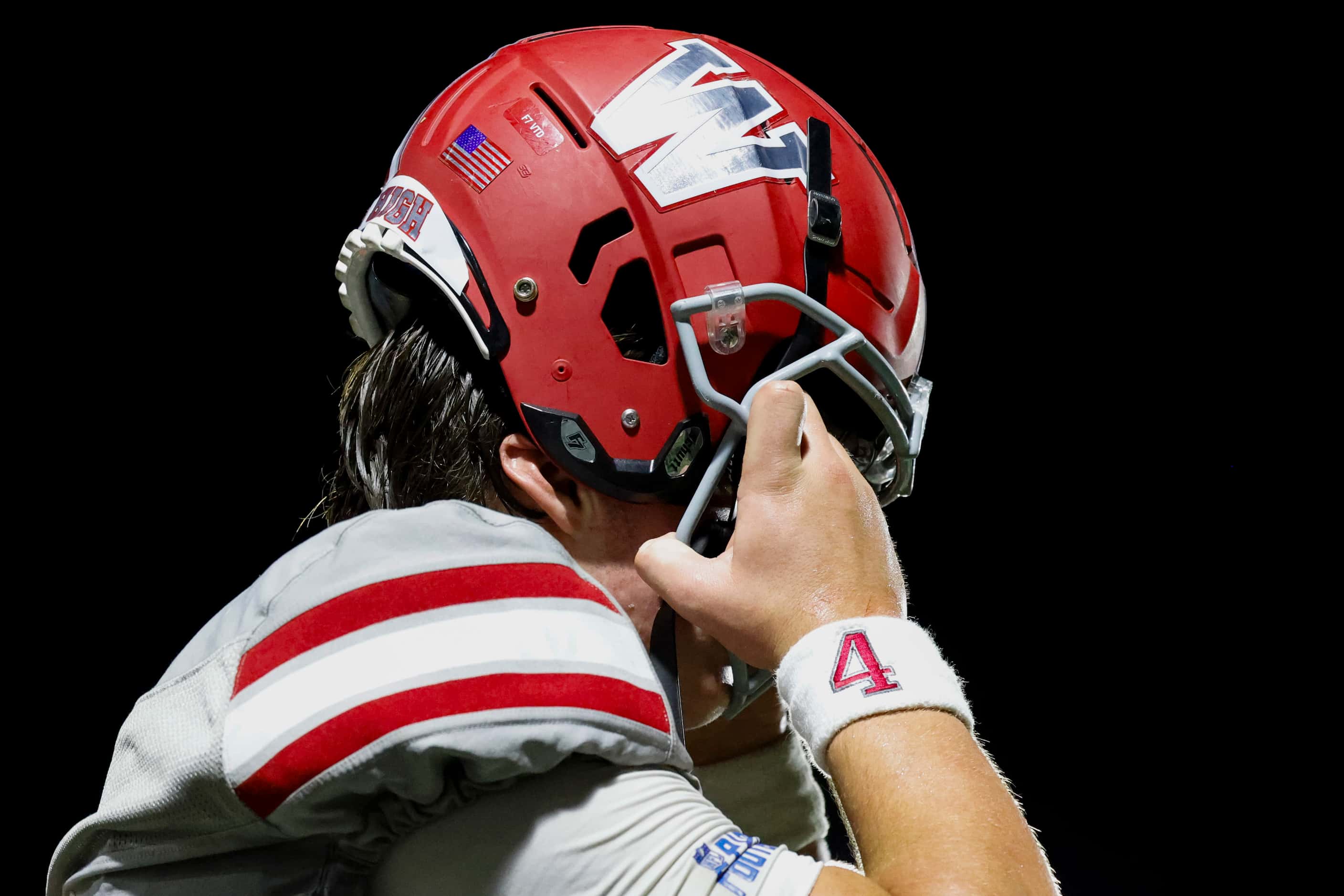 Woodrow Wilson’s QB Cam McGuire puts on his helmet before subbed into the field during the...