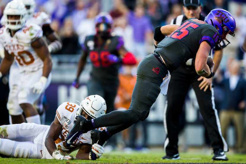 FILE - TCU quarterback Max Duggan (15) falls into the end zone for a touchdown while being...