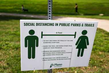 A sign displays social distancing practices at Bob Woodruff Park in Plano, Texas on Tuesday,...