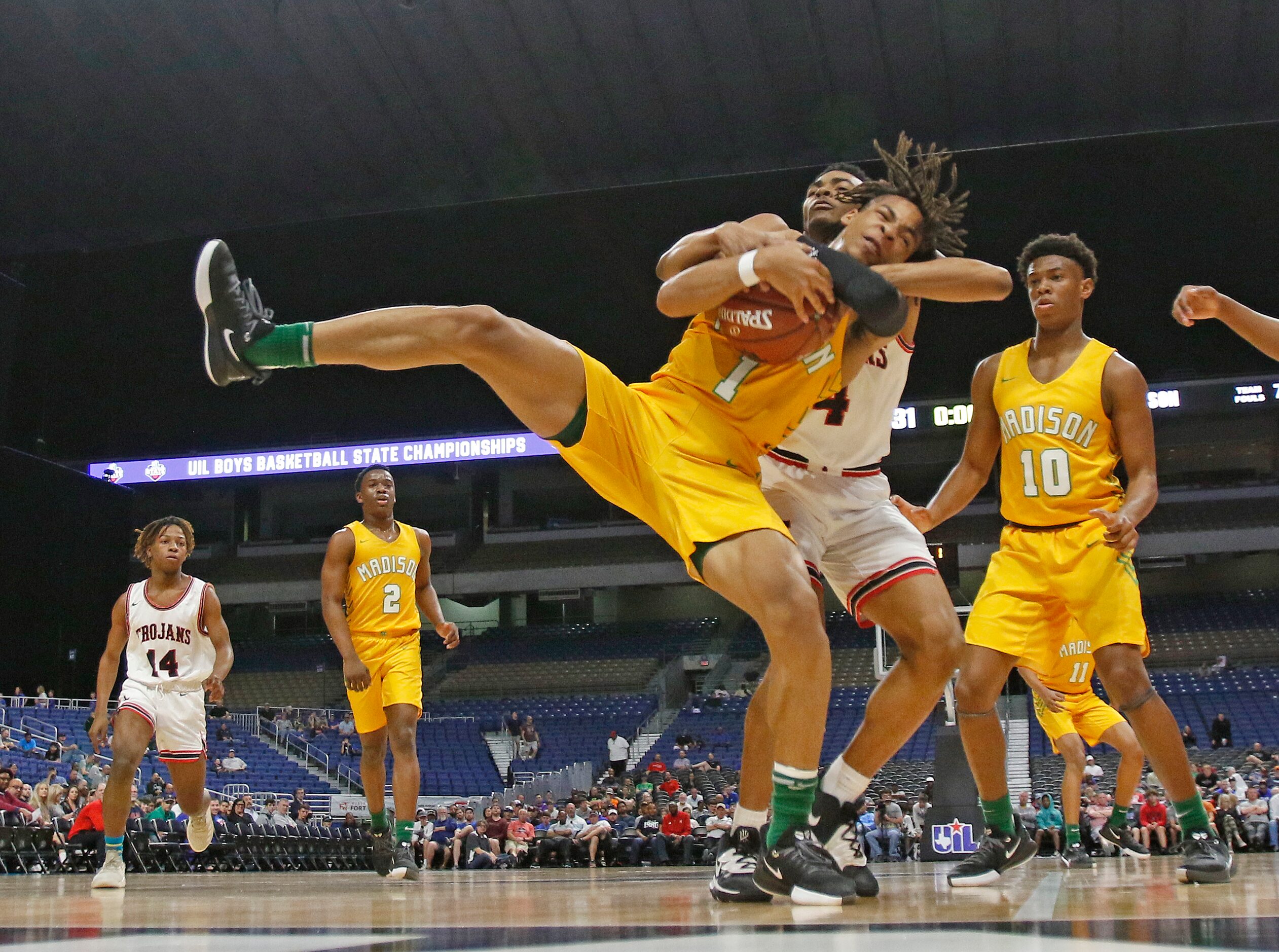 Madison guard Pierre Hunter #1 is tied up by Coldspring-Oakhurst  Jared Curry #4. Madison...