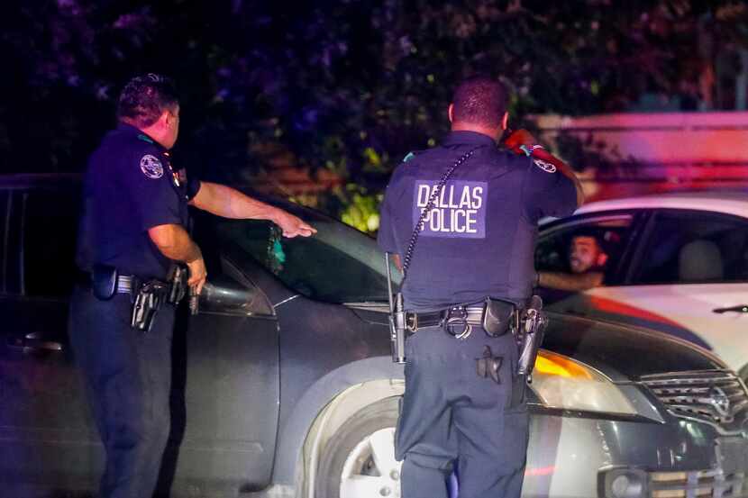 Dallas Police Deputy Chief Israel Herrera (left) and another officer give commands to the...