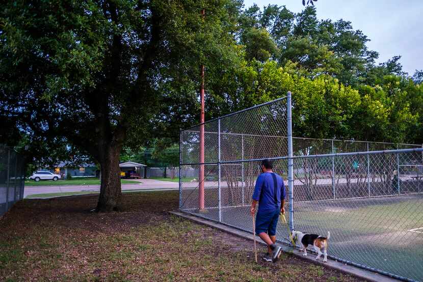 A man walked a dog past tennis courts at Ferguson Park on Monday near the site where two...