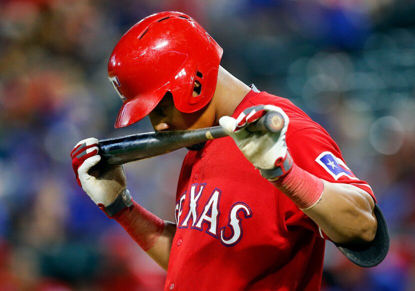 Texas Rangers left fielder Carlos Gomez (14) takes a sniff of his bat before stepping into...