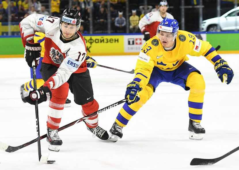 Sweden's Mattias Janmark and Austria's Manuel Ganahl vie for the puck during the group A...