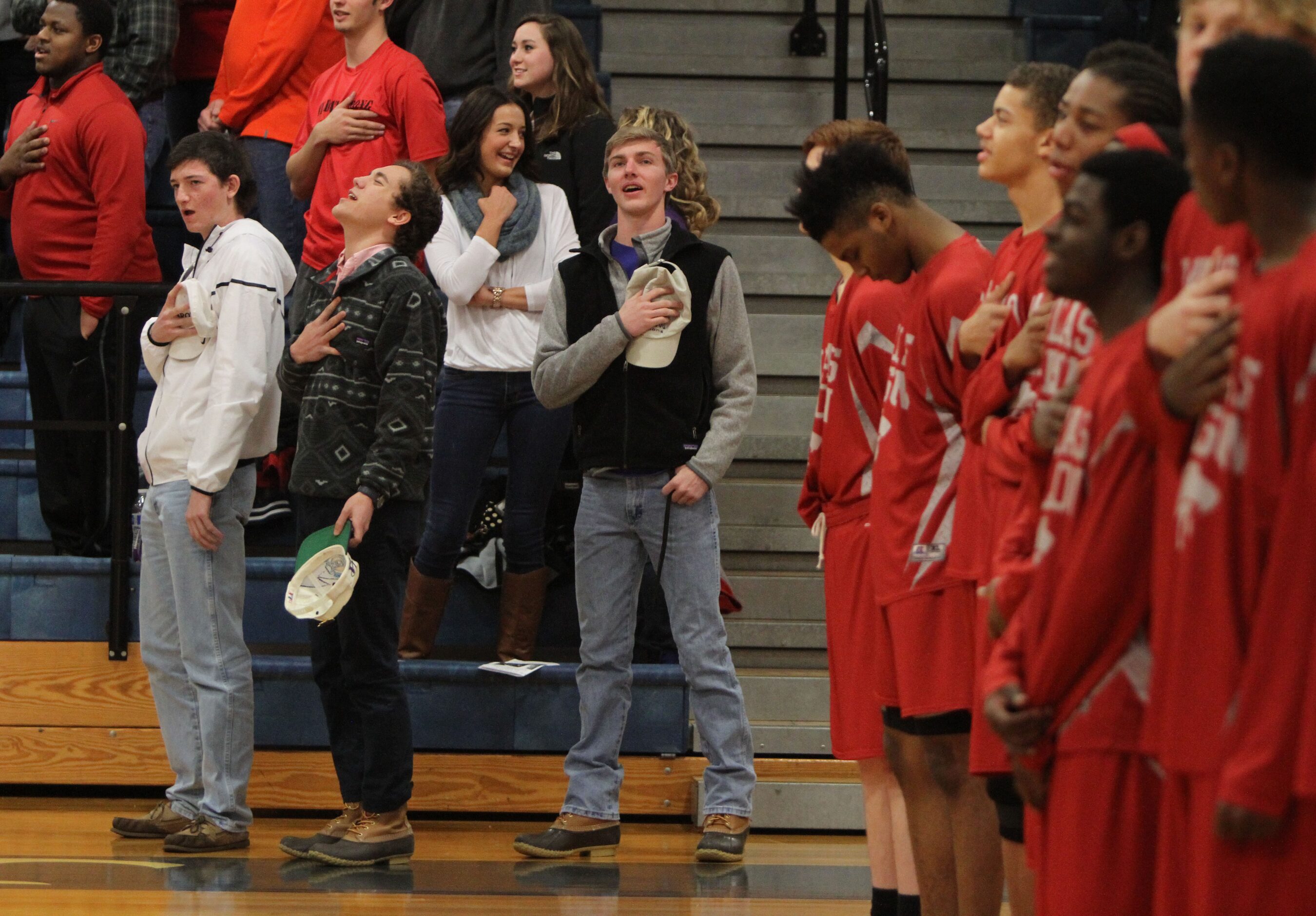 Woodrow Wilson student Andrew Derouen kicks his head back as he leads the crowd in an...