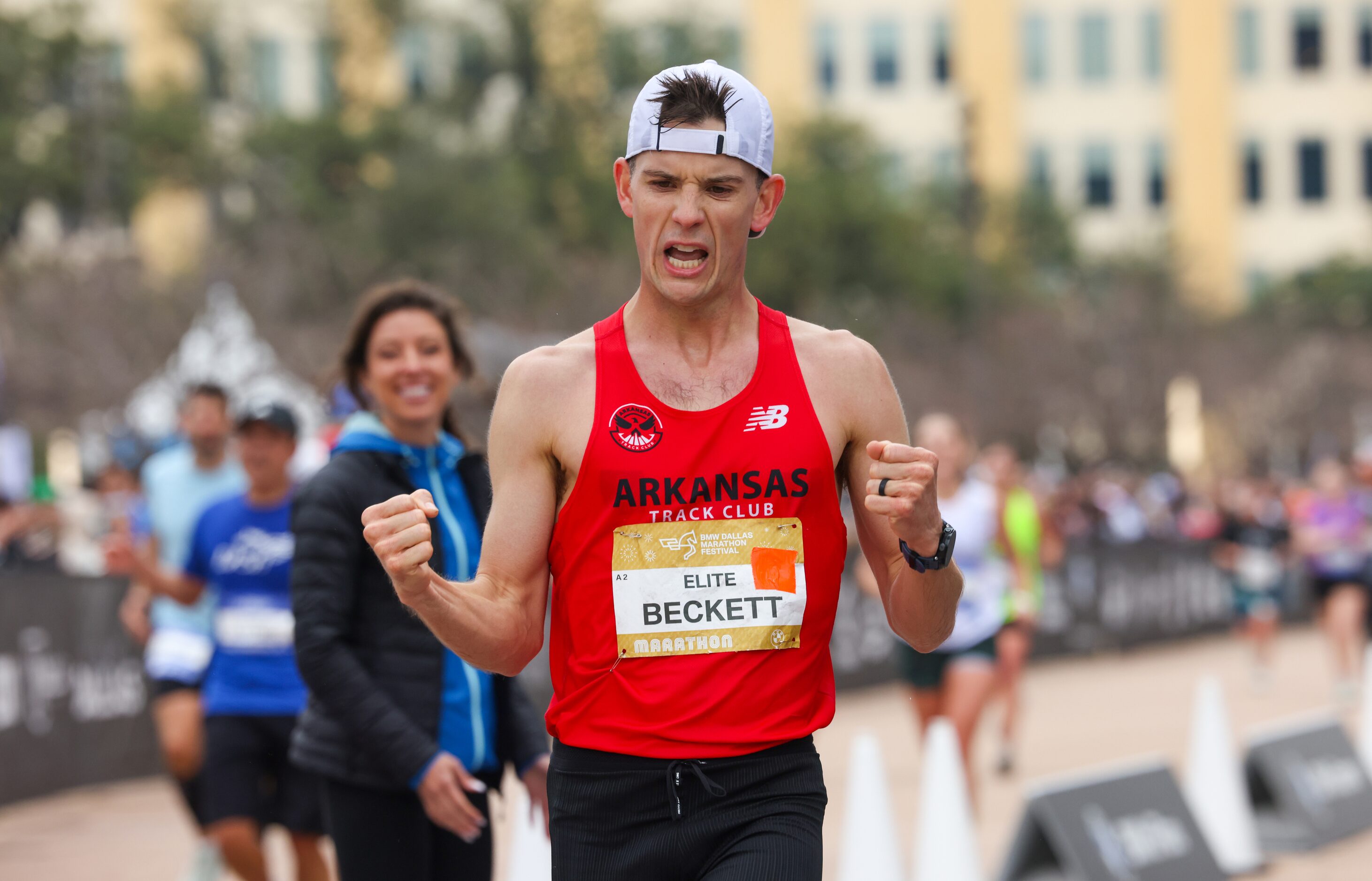 Cameron Beckett pumps his fists in the air as he crosses the finish line in first place at...