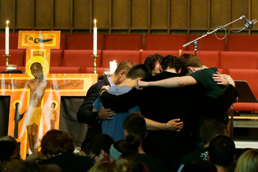 A group of people pray in a circle at the end of a prayer service Friday, June 6, 2014, at...