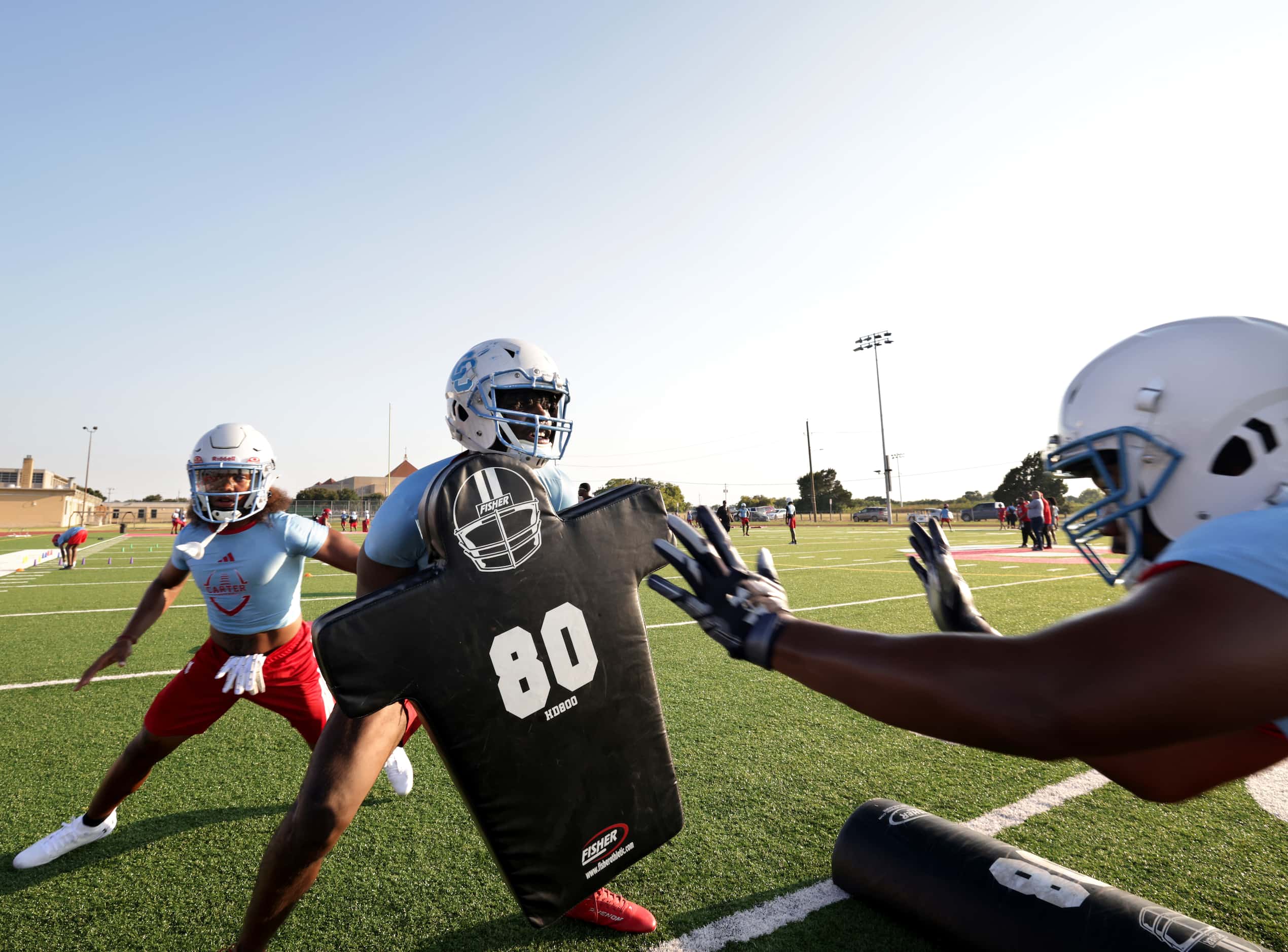 Cuvanti Crawford, center, runs a drill during football practice at Carter High School in...