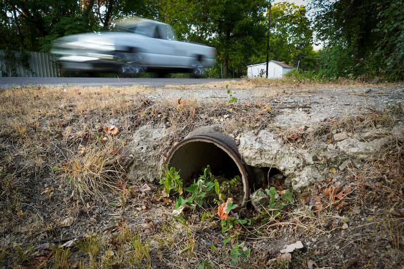 Traffic on Pueblo Street passes a crumbling drainage culvert in West Dallas on Wednesday,...