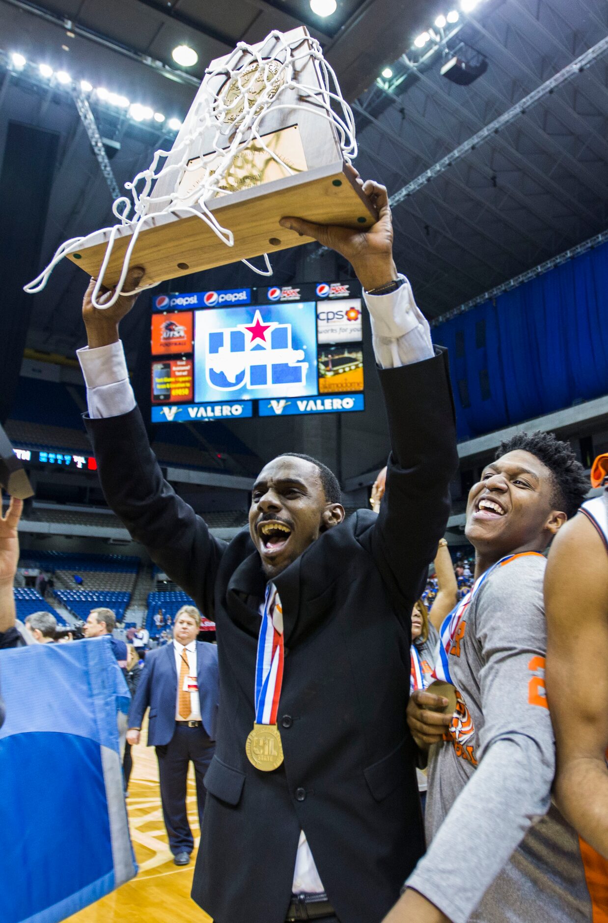 Lancaster head coach Ferrin Douglas and players celebrate a 59-47 win over Beaumont Ozen at...