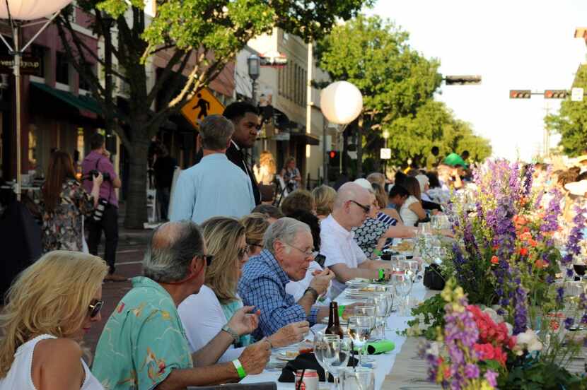 Guests eat and drink food prepared by Cafe Momentum students at Night Out on 15th Street in...