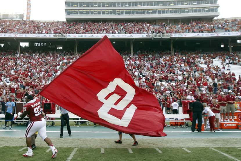 Oklahoma Sooners defensive tackle Jamarkus McFarland (97) waves the OU flag after they...