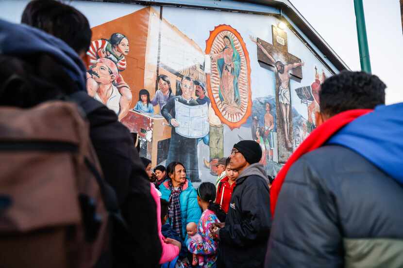 Migrants wait outside the Centro Pastoral Sagrado Corazon for overnight shelter in El Paso...