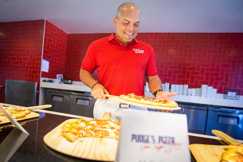 Hall of Fame Texas Rangers catcher Ivan "Pudge" Rodriguez shows off samples of pizza that...