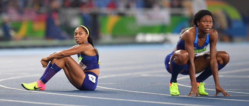 U.S. athletes Allyson Felix, left, and Phyllis Francis watch the replay of the finish of...