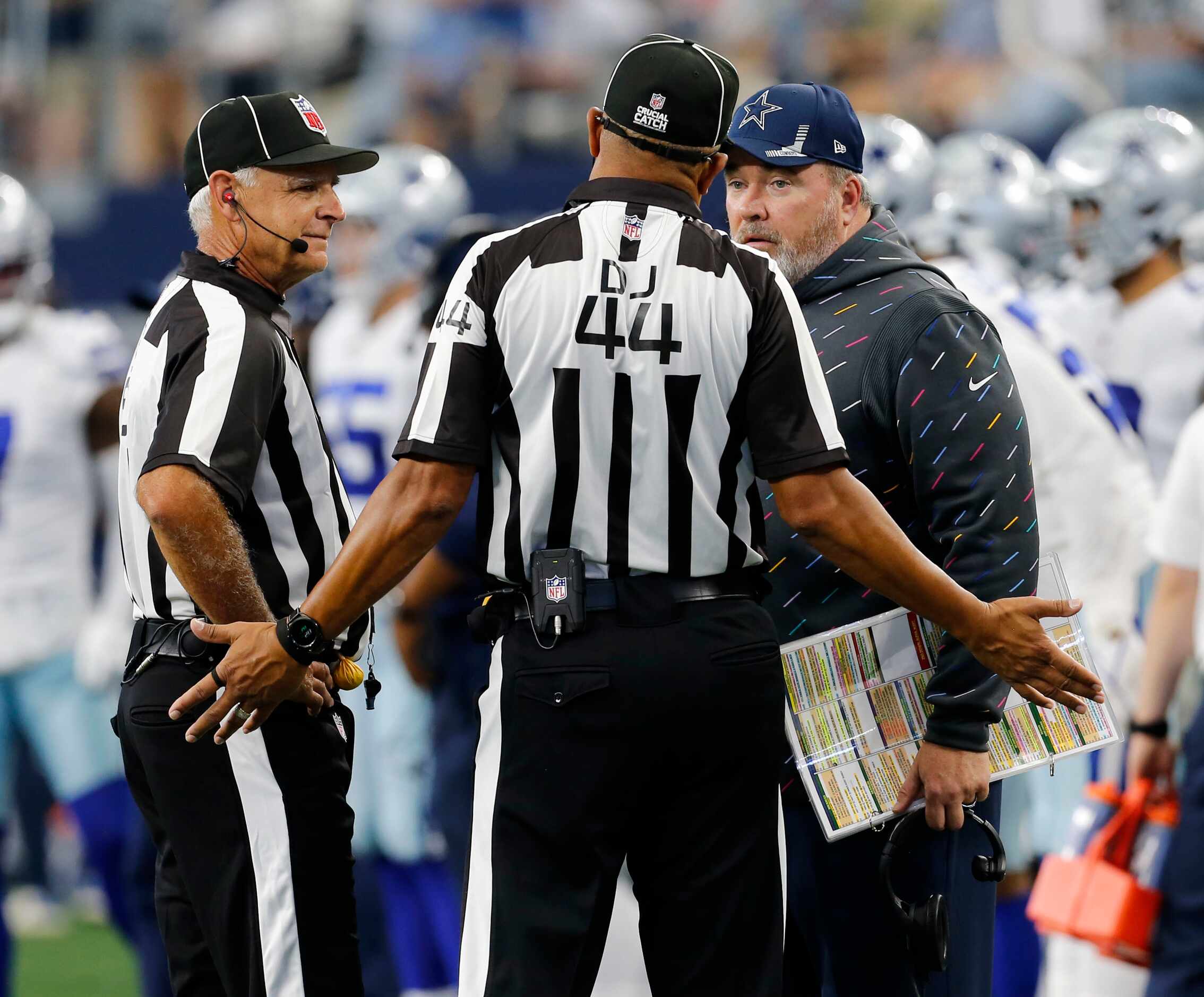 An official tries to explain a ruling to Dallas Cowboys head coach Mike McCarthy during the...