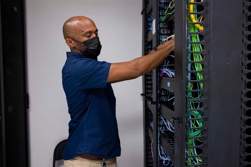 Tech analyst Jason Oliver checks the server room at the Perkins Coie office in Dallas.